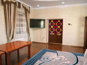 ein Wohnzimmer mit einem Holztisch und einer Tür in der Unterkunft Adorable 3 bedroom house villa with mountain view and beautiful garden in Baytyk