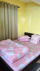 a bedroom with two beds with pink sheets and pillows at Dew Drops Guest House in Darjeeling