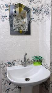 a white sink in a bathroom with a mirror at Dew Drops Guest House in Darjeeling