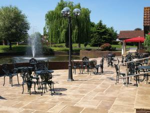un patio al aire libre con mesas, sillas y una fuente. en Three Counties Hotel, en Hereford
