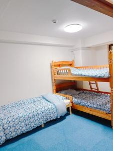 長崎的住宿－ひまわりHotel，一间卧室配有两张双层床,铺有蓝色地毯。