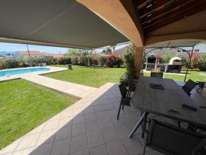 un patio con mesa y sillas bajo una sombrilla en Modern Villa Flovin with swimming pool, en Vidauban