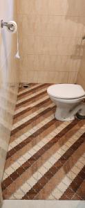 uma casa de banho com um WC sentado num piso de azulejo em Casa De Cris em Cavelossim
