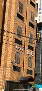 a tall brick building with asian writing on it at ひまわりHotel in Nagasaki