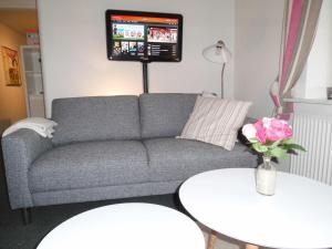 a living room with a gray couch and two tables at Give City Apartments in Give