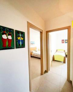 a room with two paintings on the wall and a bedroom at Djadsal Moradias in Santa Maria