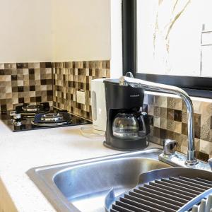 a kitchen sink with a coffee maker on the counter at Apartamentos Vista Verde in Carmen