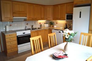 a kitchen with wooden cabinets and a white refrigerator at Apartments Borg Kalskeentie in Pori +15 photos