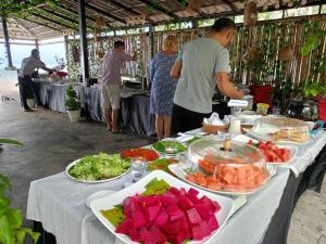 a table with food on it with people standing around at SCARLET SAILS VILLA in Koh Rong Island