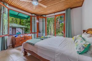 a bedroom with a bed and a large window at The Jungle Inn in Dominicalito