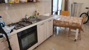 cocina con fogones, fregadero y mesa en appartamento via san pardo, en Matera