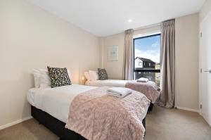 1 dormitorio con 2 camas y ventana en O'Mera Luxury Retreat, en Queenstown