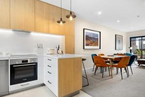 a kitchen and dining room with a table and chairs at O'Mera Luxury Retreat in Queenstown