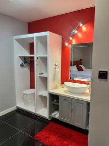 baño con lavabo y pared roja en Coconut Creek - Entire Two Bedroom Unit. en Hyde Park