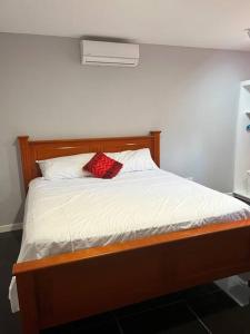 Un dormitorio con una cama con una bufanda roja. en Coconut Creek - Entire Two Bedroom Unit. en Hyde Park