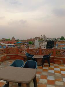 a balcony with tables and chairs and a view of a city at Hotel India inn in Agra
