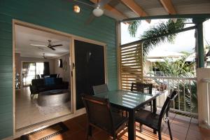 Marlin Cove Holiday Resort في شاطئ ترينيتي: شاشة في الشرفة مع وجود طاولة وكراسي