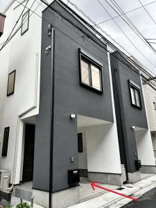 une maison noire et blanche avec une ligne rouge devant elle dans l'établissement スカイツリーまで徒步約10分、清潔、快適、便利、静か、設備完備！, à Tokyo