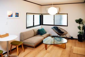 a living room with a couch and a glass table at 1stop to Shibuya station Japanese traditional house in Tokyo