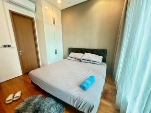 2bedroom soho suites klcc في كوالالمبور: غرفة نوم بسرير عليها غرض ازرق