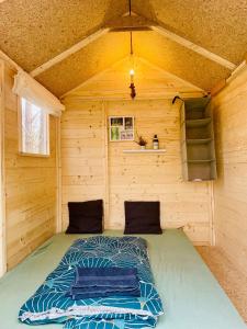 a bed in the inside of a wooden cabin at Abenteuercamp Schaeferhof Hütten oder Stellplatz für kleinen Camper oder Zelt in Cottbus