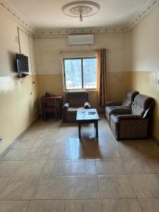 a living room with two couches and a table at Gust Hotel in Bangui