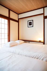 東京にある1stop to Shibuya station Japanese traditional houseの窓のある部屋に白いベッドが2つある