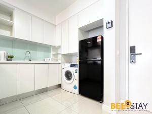 a kitchen with a black refrigerator and a washing machine at Sentral Suite KL Sentral City View 6PAX in Kuala Lumpur