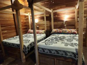 twee aparte bedden in een hut met houten wanden bij Mansud Shores Beach Resort - Talikud Island in Davao City