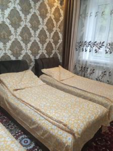 - deux lits jumeaux installés dans une chambre avec des rideaux dans l'établissement Бакай 1, à Arkit
