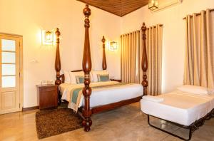 a bedroom with two beds and a nightstand and a bed sidx sidx sidx sidx at Simpson's Forest Hotel in Kandy