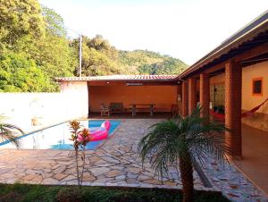 ein Haus mit einem Pool und einer Terrasse in der Unterkunft Chácara isabella in Socorro