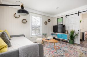 Una sala de estar con un sofá, un televisor y una mesa. en Contemporary Mid-Century Style Downtown AC, en Traverse City