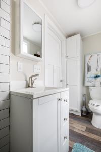 Un baño blanco con lavabo e inodoro. en Contemporary Mid-Century Style Downtown AC, en Traverse City 32 fotos más