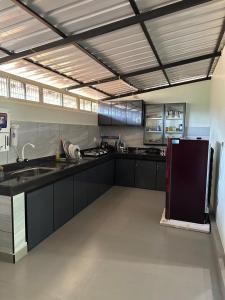 a large kitchen with black counter tops and appliances at Amour Estate in Periya