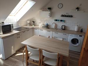 a kitchen with a table and a sink and a microwave at Górskie Marzenie - Apartament i Domek z sauną blisko Zatora i Energylandii in Przeciszów