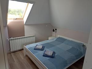 a bedroom with a bed with two towels on it at Górskie Marzenie - Apartament i Domek z sauną blisko Zatora i Energylandii in Przeciszów