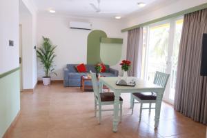 un soggiorno con tavolo, sedie e divano di Richmonde Ananta Elite Luxurious Villa & Apartments,Goa a Baga