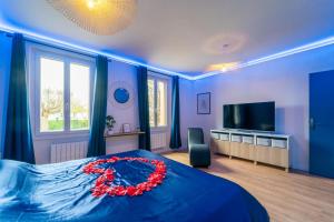 Un dormitorio con una cama azul con una corona roja. en Suite Eden - Love Room en Coulommiers