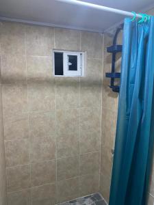 a shower with a blue curtain in a bathroom at Miss Titi's Native Lodge in San Andrés