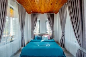 a bedroom with two beds in front of windows at Điểm du lịch canh nông Avocado Farm in Lac Nghĩa