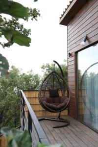 une chaise en osier assise sur une terrasse dans l'établissement Alma house - White, à Almaty