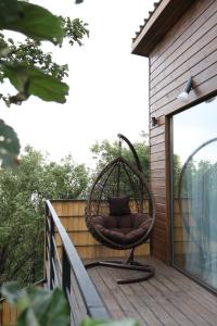 a wicker chair sitting on a deck at Alma house - White in Almaty