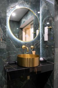 baño con lavabo de oro y espejo en Limassol Old Town Mansion en Limassol
