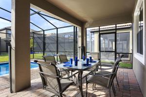 a dining room with a table and chairs on a patio at Champions Gate Villa CG014 in Orlando