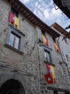un edificio con bandiere colorate su un lato di La Dimora di Pietra a Gubbio