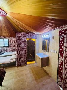Sunrise Luxury Camp في وادي رم: غرفة نوم بسرير ومغسلة في غرفة