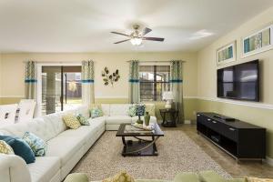 a living room with a white couch and a tv at Champions Gate Villa CG014 in Orlando