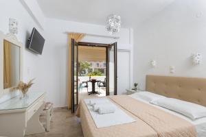 a bedroom with a large bed and a table at Vassiliki Rooms in Parikia