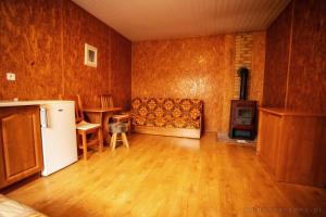 an empty living room with a couch and a refrigerator at Agroturystyka Spokojna domek 5 osobowy in Pogorzelica